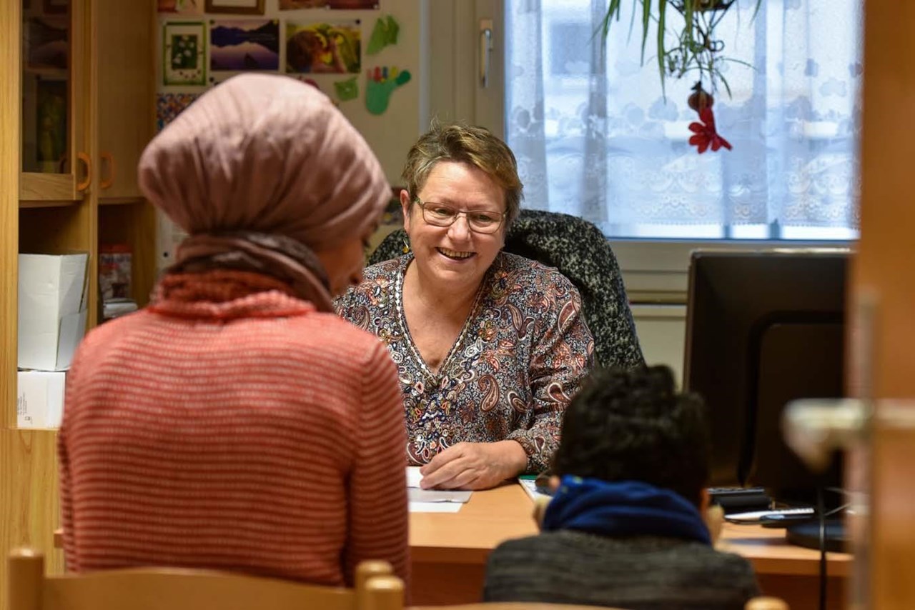 Eine Quartiersarbeiterin berät eine Mutter und ihren kleinen Sohn